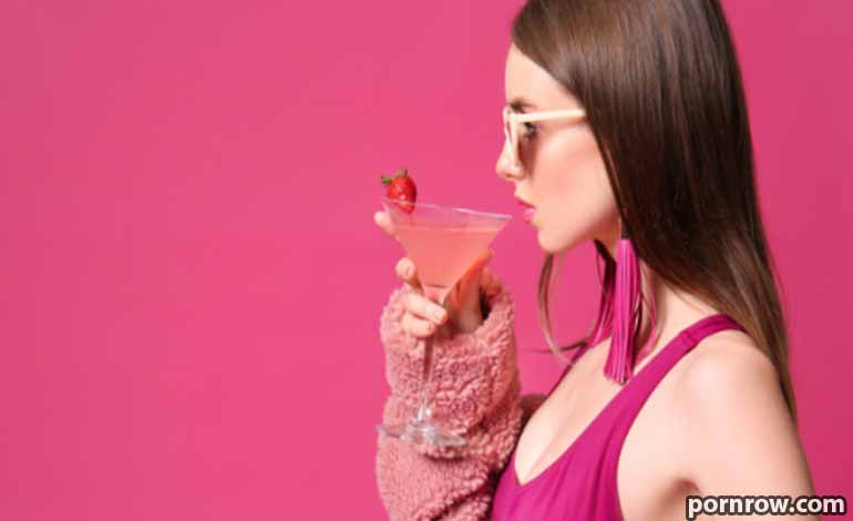 Love and a Marriage: The Best Guide to Long-Term Happiness Woman in a pink top and sunglasses sipping a pink cocktail with a strawberry garnish against a pink background.