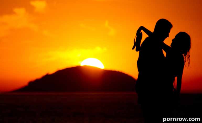 Adult Sex Tips: Learn About Consent, Comfort, and Healthy Boundaries Silhouetted couple dancing on a beach at sunset, with a bright orange sky and the sun near the horizon behind them.